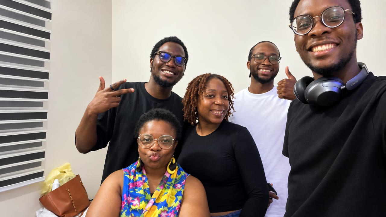 Five people smiling together in a group photo